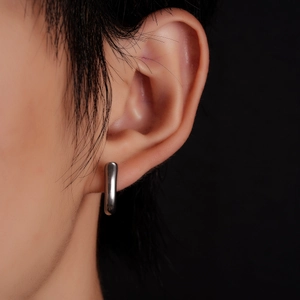 Minimalist silver titanium steel geometric earrings shown on a model with black background