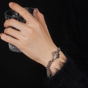 Close-up of retro stainless steel Cuban chain bracelet with vintage carved cross detail