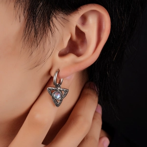 Détail de la boucle d'oreille triangle en acier titane avec nœud celtique et opale
