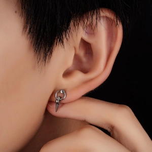 Macro view of vintage silver spike earring on ear, showing the punk style jewelry texture