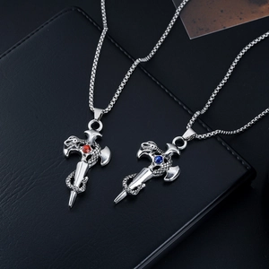 Detail of gothic snake sword pendant with red and blue gemstones on a steel chain