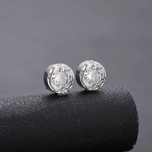 Detailed macro view of silver stud earrings with cubic zirconia and vintage engraving