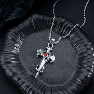 Detailed close-up of a vintage steel sword and snake pendant with a red gemstone center