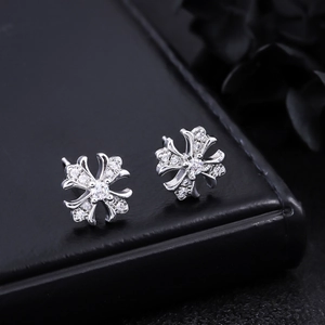 Vue macro de boucles d'oreilles croix fleur de lys en argent avec zircone sur cuir noir