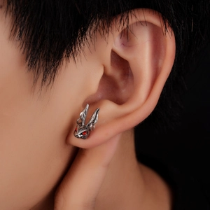 Macro shot of a punk style stainless steel rabbit stud earring with red gem eyes