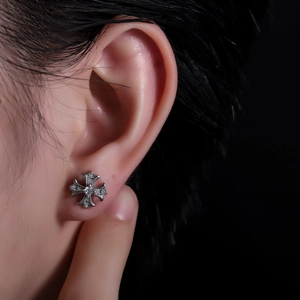 Vue rapprochée du clou d'oreille croix gothique avec finition argentée et zircons