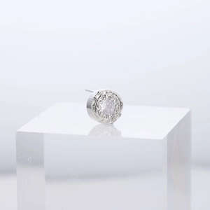 Detailed view of silver-toned round stud earring with micro-set zircon and vintage engraving