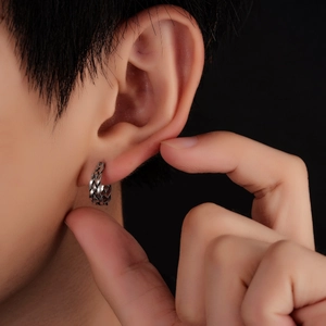 Gros plan de boucles d'oreilles en acier titane vintage avec texture tressée