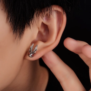 Macro shot of punk rabbit ear stud with red eyes and vintage silver finish