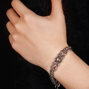 Macro view of retro lion head bracelet featuring hollow heart links and metal relief detail