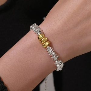 Detail of silver and gold hematite beaded bracelet with adjustable metal chain on wrist
