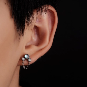 Gros plan de boucles d'oreilles en titane avec perle de lune bleue, zircon et chaîne argent