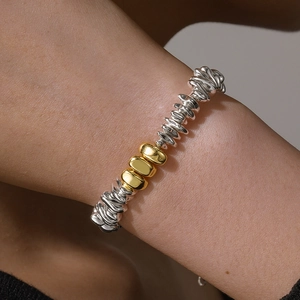 Modern gold and silver mixed beaded bracelet with textured metallic pebble design
