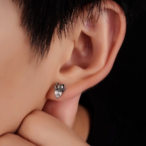 Detail of angel bear titanium steel earring with heart cubic zirconia on ear
