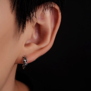 Macro shot of silver rose stud earring with a central zircon stone on earlobe