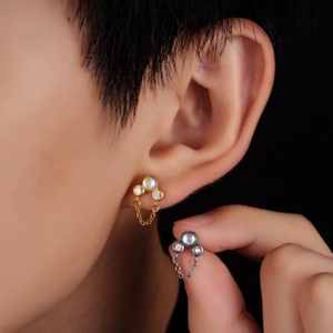 Clou d'oreille en titane avec trois diamants et opale irisée sur fond noir élégant