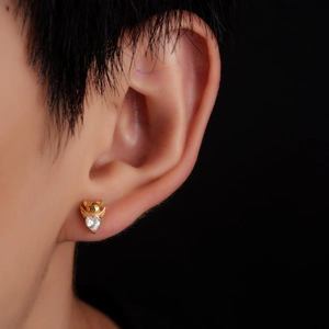 Macro detail of gold-plated angel bear earring with sparkling heart-shaped zircon stone
