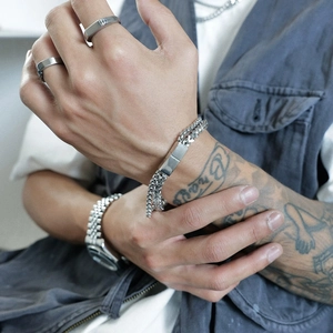 Double-layered titanium steel chain bracelet with a polished metal plate on a male wrist