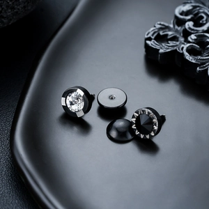Détail macro de boucles d'oreilles en acier titane avec zircone et bords texturés