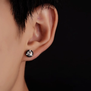 Détail d'un clou d'oreille rond en titane avec anneau noir et pierre de zircon brillant