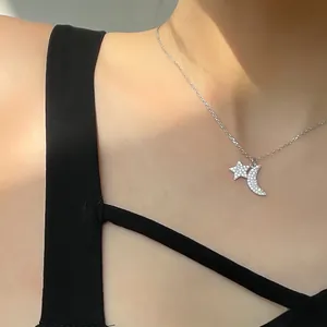 Detail showing an elegant silver star and moon pendant necklace with white zircons on model