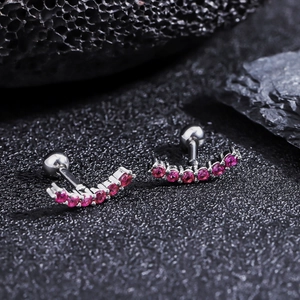 Détail macro de boucles d'oreilles croissant en titane avec sept zircons roses étincelants