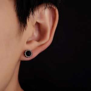 Gros plan d'une boucle d'oreille en acier titane avec zircon noir et bordure radiale