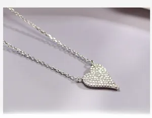 Detailed close-up of a 925 sterling silver heart pendant with pavé-set shimmering crystals