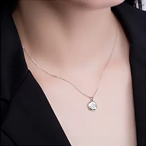 Macro shot of S925 silver star pendant necklace worn by a model in formal attire