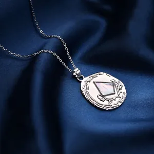 Halskette aus S925 Sterlingsilber mit Muschelanhänger auf blauem Seidenstoff