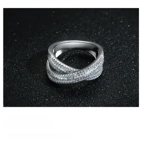 Dettaglio macro di anello incrociato in argento S925 con pavé di zirconi bianchi