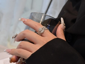 Detail of S925 sterling silver daisy ring featuring micro-pave crystals on model's hand