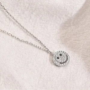 S925 sterling silver smiley face necklace with sparkling zircon pavé on white fabric