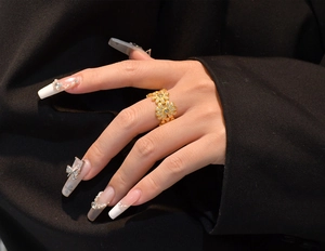 Close-up of S925 silver daisy ring with micro-pave crystals on a golden band