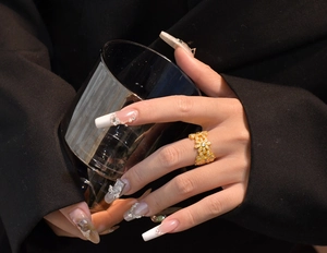 Detail of a gold plated daisy ring with micro paved cubic zirconia worn by a model