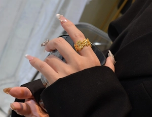 Detail of s925 silver daisy ring with gold plating and zircons on woman's finger