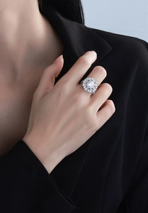 Gros plan détaillé d'une bague fleur en argent avec une grande pierre centrale sur un mannequin