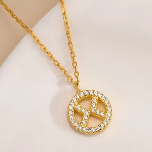 Detailed view of a gold S925 silver necklace with a zircon-encrusted X pendant