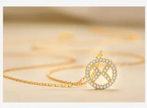 Macro view of gold S925 sterling silver geometric X-shaped pendant with white zircons