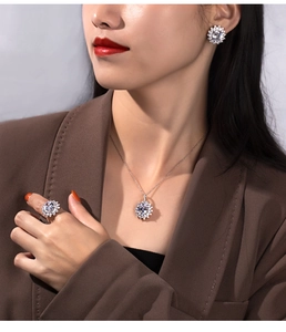 Close-up of elegant S925 silver jewelry set worn by model featuring necklace and earrings