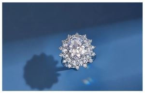 Detail of S925 silver sunflower ring with oval crystal and sparkling halo on blue background
