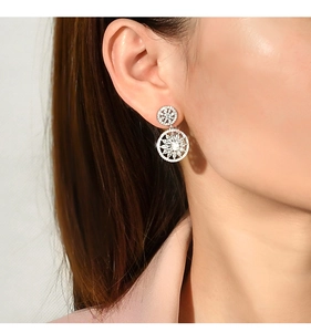 Close-up of S925 sterling silver snowflake earrings with sparkling zircon on model