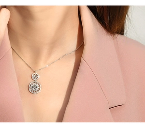 Close-up of double circular sunflower pendants on an elegant silver necklace for women