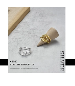 Macro detail of intertwined sterling silver rings in gold and silver finish
