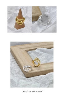 Detailed view of twisted intertwining geometric rings in gold and silver finishes