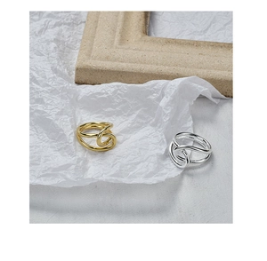 Artistic detail of gold and silver intertwined twist rings on textured background