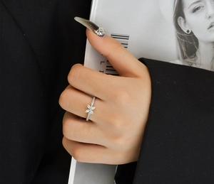 Détail d'une bague en argent s925 avec papillon en zircon scintillant portée au doigt