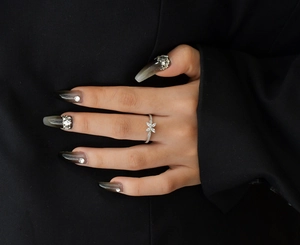 Gros plan sur bague trèfle en argent S925 avec micro-pavage de zircons sur fond de costume