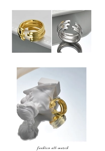 Three-layer adjustable silver and gold open rings on white marble background