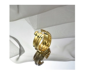 Detail of gold double spiral nail ring with high polished finish on white silk